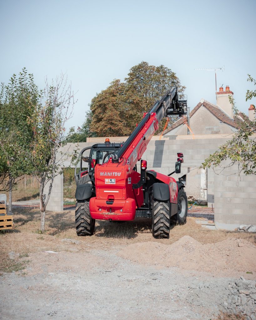Engin de levage près d’une extension en construction à Pouzy-Mésangy, pendant le chantier de toiture.