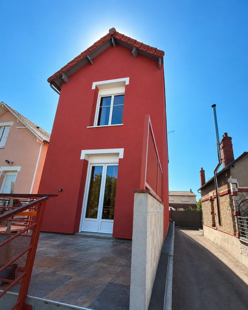 Maison à Bourges avec façade rouge et encadrements clairs après isolation extérieure.
