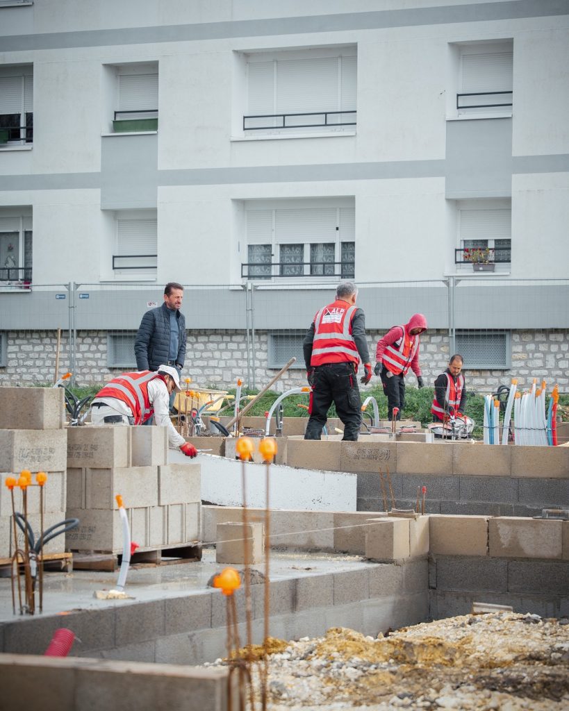 Équipe ALP sur un chantier de maçonnerie à Cosne-Cours-sur-Loire, avec murs en blocs en cours d’élévation.