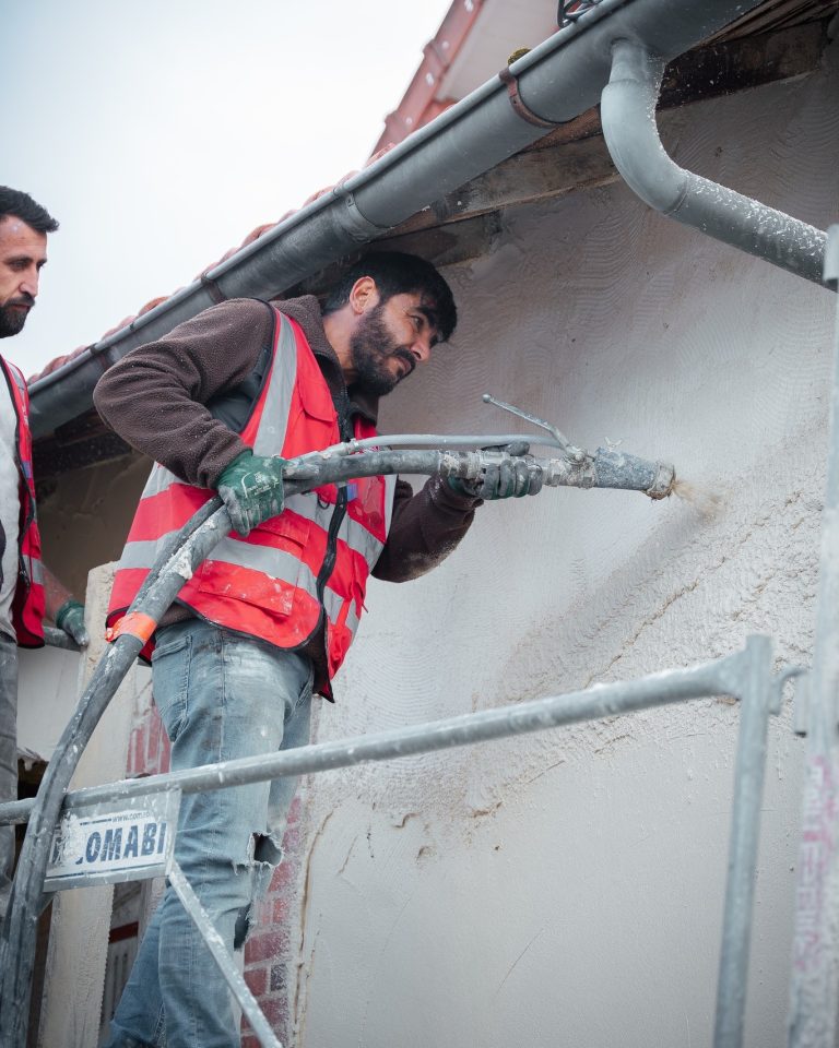 &Eacute;quipe ALP au travail : fa&ccedil;ades et enduits, avec le logo ALP visible sur les v&ecirc;tements.