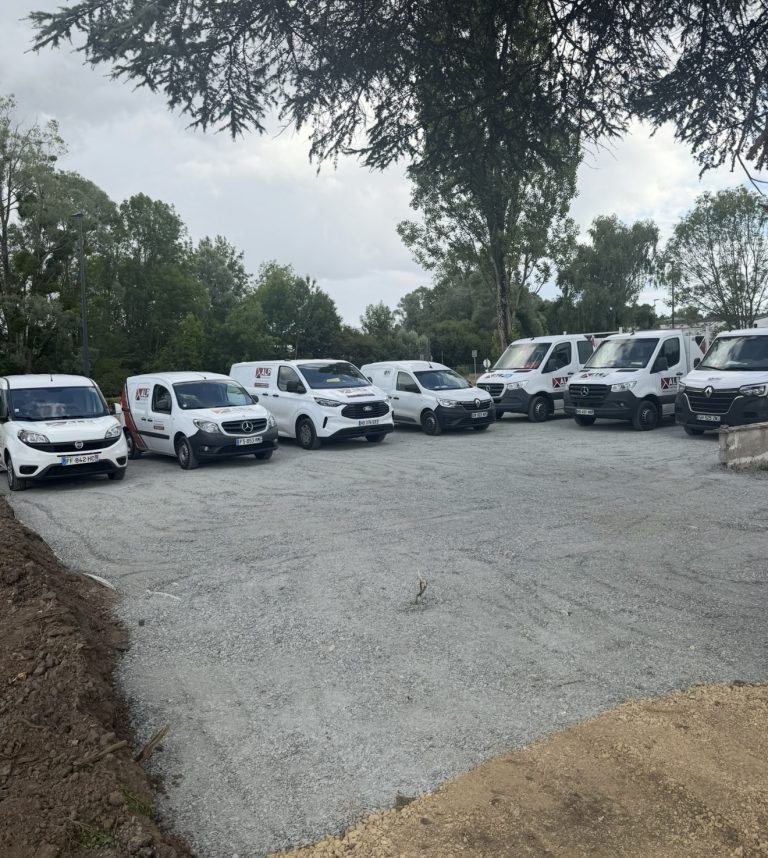 Une partie des camions et utilitaires ALP Construction align&eacute;s sur le parking, avec les logos ALP visibles.