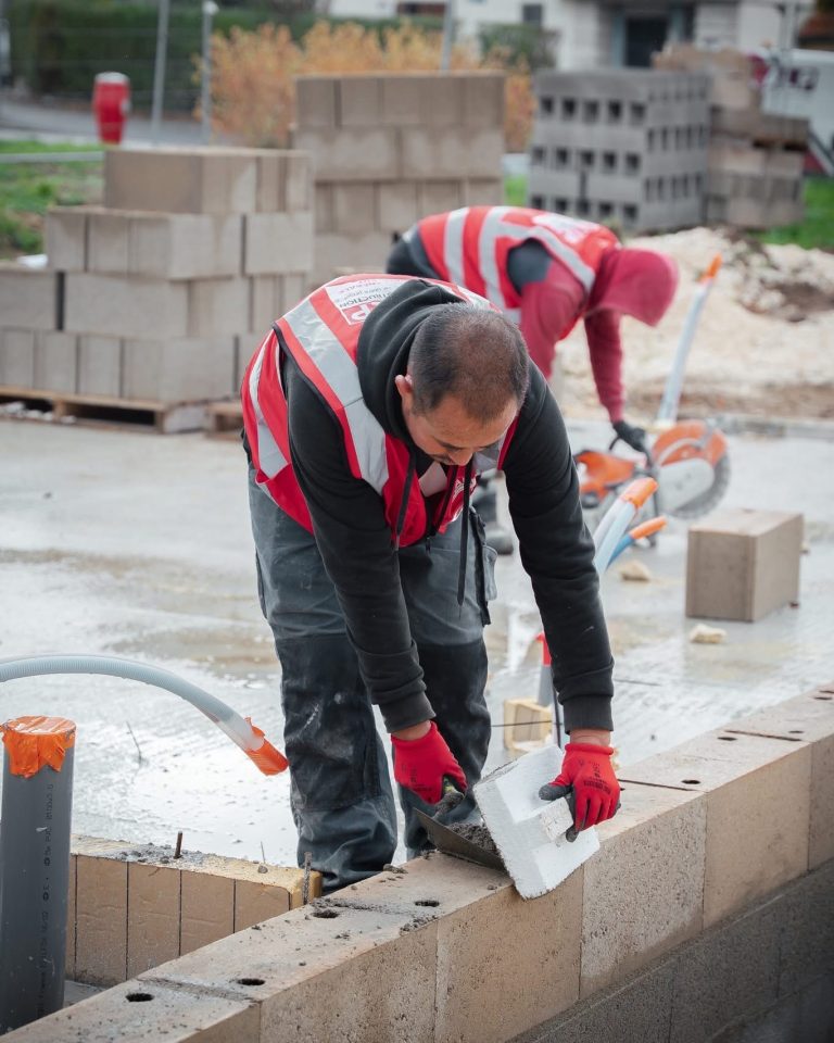 &Eacute;quipe ALP au travail : b&eacute;ton et ma&ccedil;onnerie, avec le logo ALP visible sur les v&ecirc;tements.