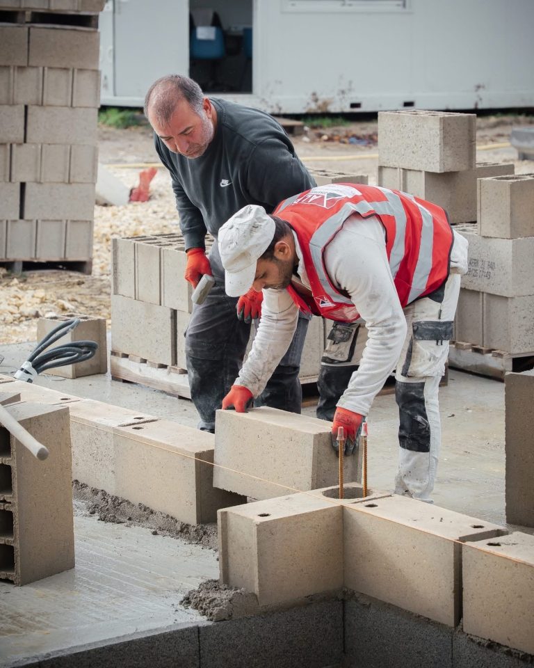 &Eacute;quipe ALP au travail : b&eacute;ton et ma&ccedil;onnerie, avec le logo ALP visible sur les v&ecirc;tements.