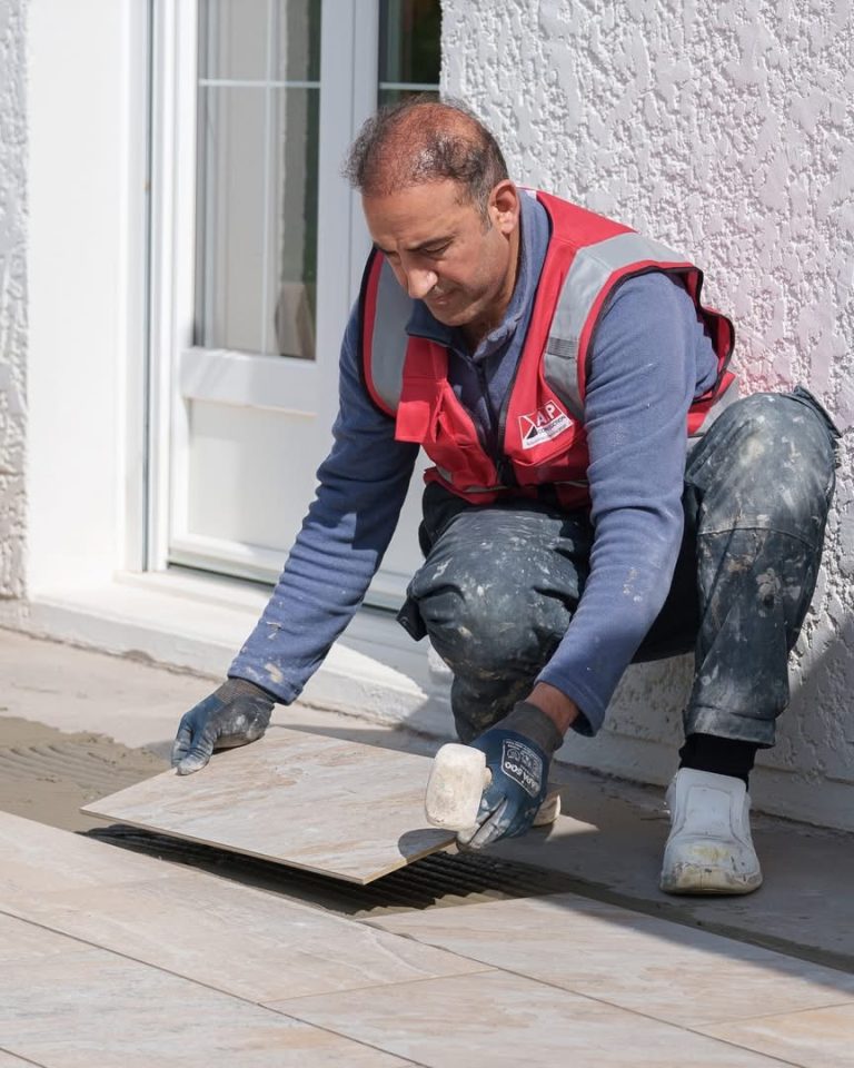 &Eacute;quipe ALP au travail : carrelage, avec le logo ALP visible sur les v&ecirc;tements.
