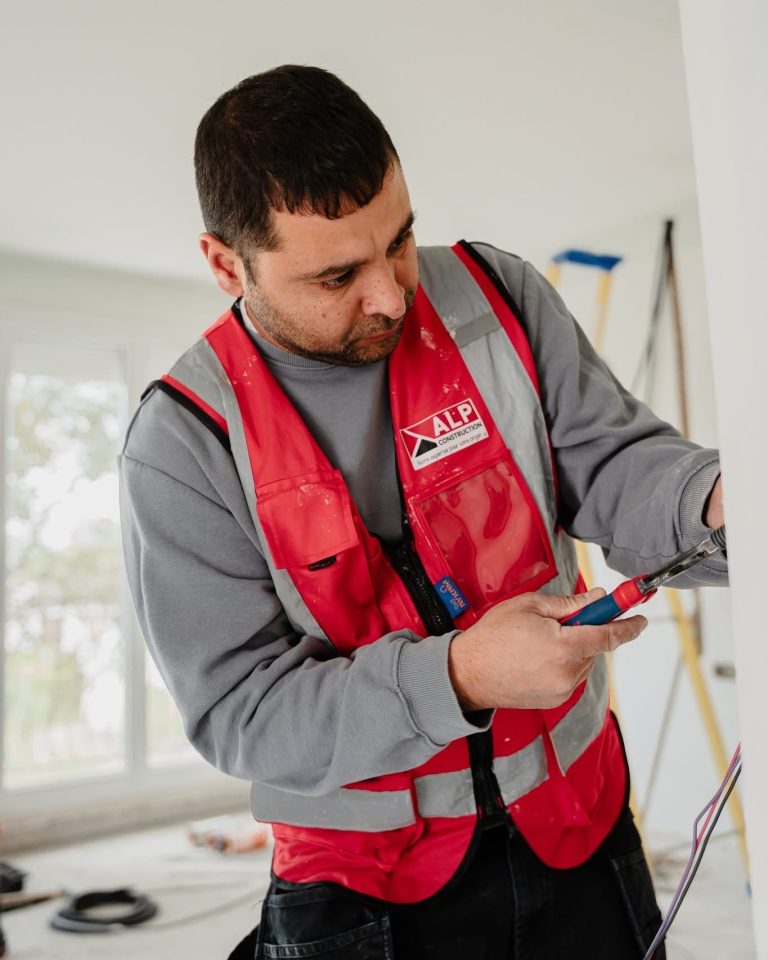 &Eacute;quipe ALP au travail : &eacute;lectricit&eacute;, avec le logo ALP visible sur les v&ecirc;tements.
