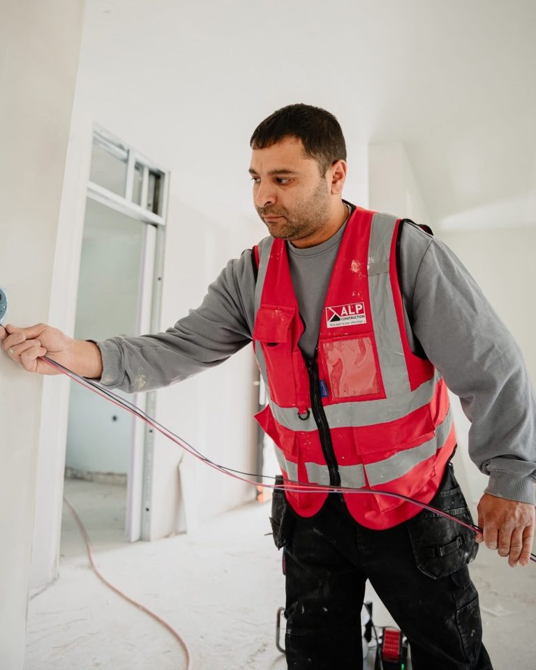 &Eacute;quipe ALP au travail : &eacute;lectricit&eacute;, avec le logo ALP visible sur les v&ecirc;tements.