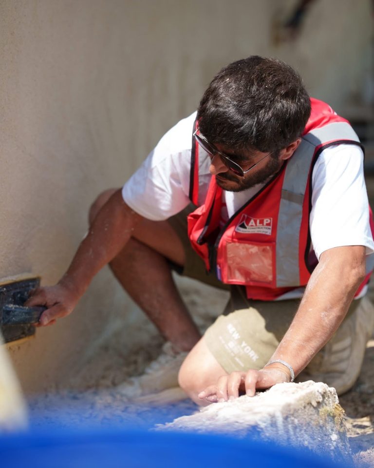 &Eacute;quipe ALP au travail : fa&ccedil;ades et enduits, avec le logo ALP visible sur les v&ecirc;tements.