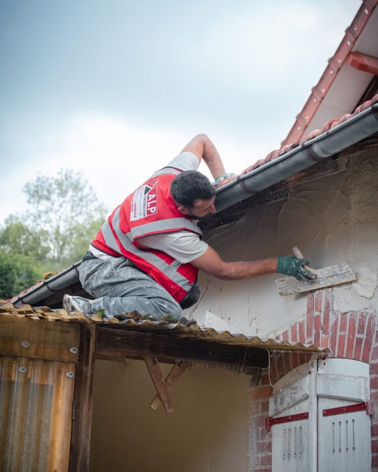 &Eacute;quipe ALP au travail : fa&ccedil;ades et enduits, avec le logo ALP visible sur les v&ecirc;tements.