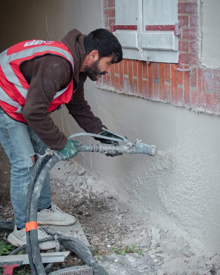 &Eacute;quipe ALP au travail : fa&ccedil;ades et enduits, avec le logo ALP visible sur les v&ecirc;tements.