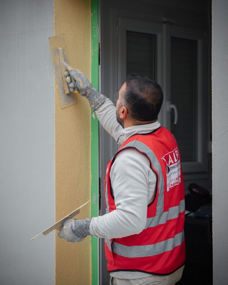 &Eacute;quipe ALP au travail : fa&ccedil;ades et enduits, avec le logo ALP visible sur les v&ecirc;tements.