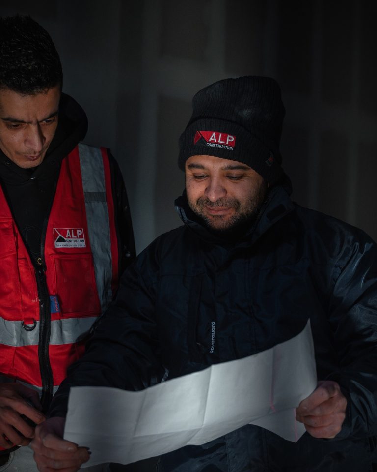 &Eacute;quipe ALP au travail : pl&acirc;trerie et r&eacute;novation, avec le logo ALP visible sur les v&ecirc;tements.