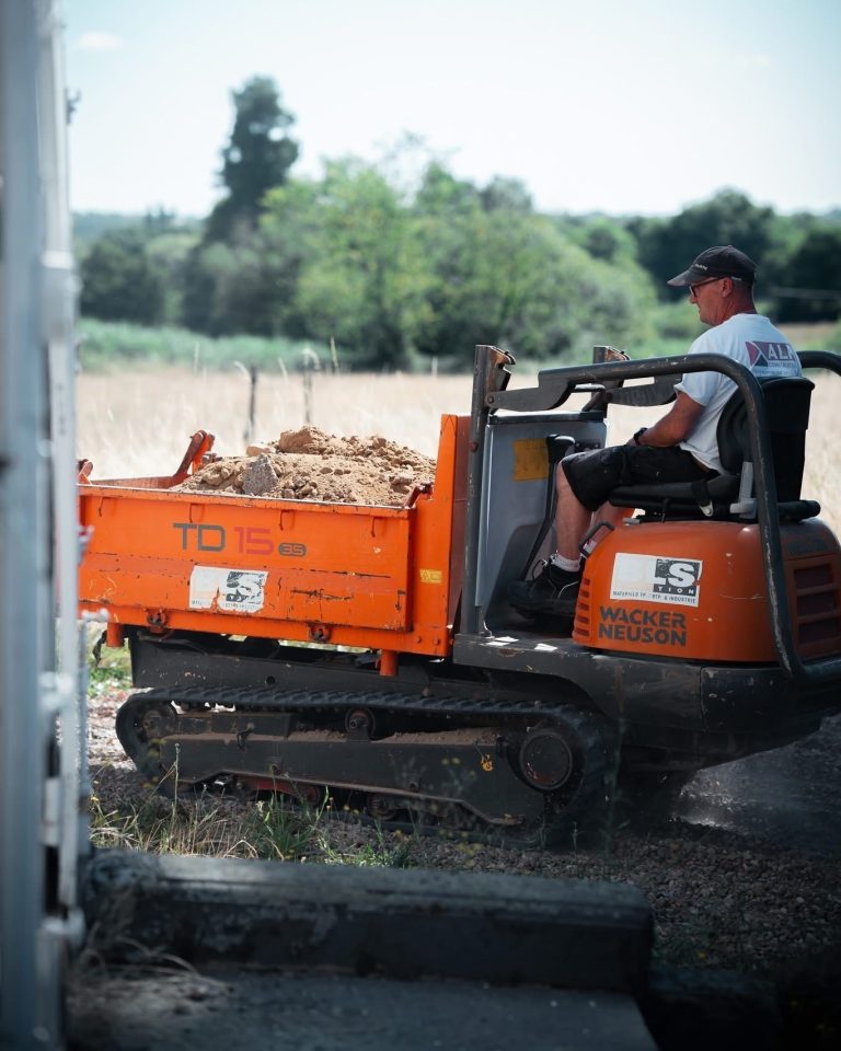 &Eacute;quipe ALP au travail : terrassement et engins, avec le logo ALP visible sur les v&ecirc;tements.