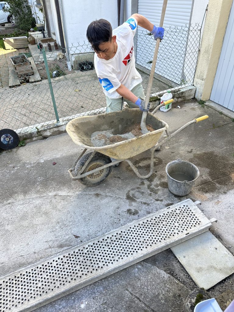 Équipe ALP au travail : béton et maçonnerie, avec le logo ALP visible sur les vêtements.