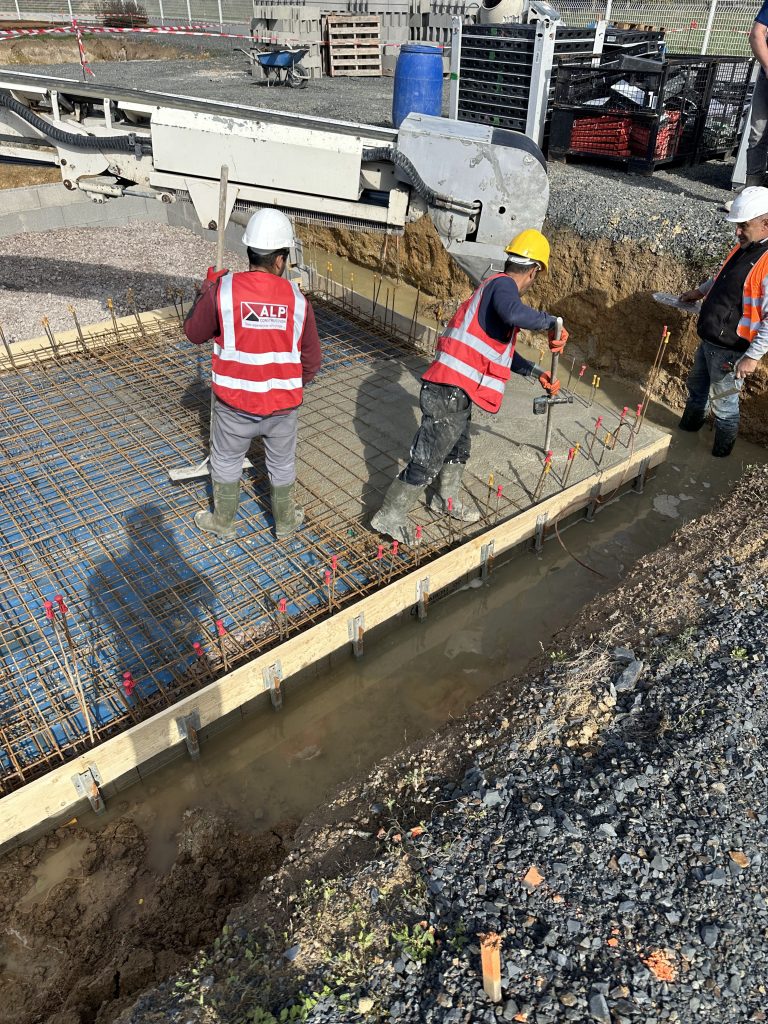 Équipe ALP au travail : béton et maçonnerie, avec le logo ALP visible sur les vêtements.