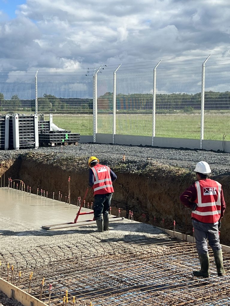 Équipe ALP au travail : béton et maçonnerie, avec le logo ALP visible sur les vêtements.