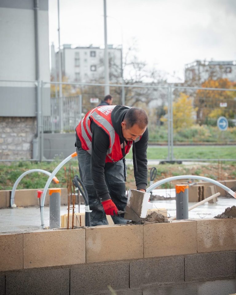 Équipe ALP au travail : béton et maçonnerie, avec le logo ALP visible sur les vêtements.