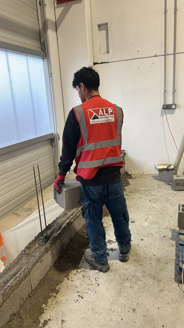 Équipe ALP au travail : béton et maçonnerie, avec le logo ALP visible sur les vêtements.