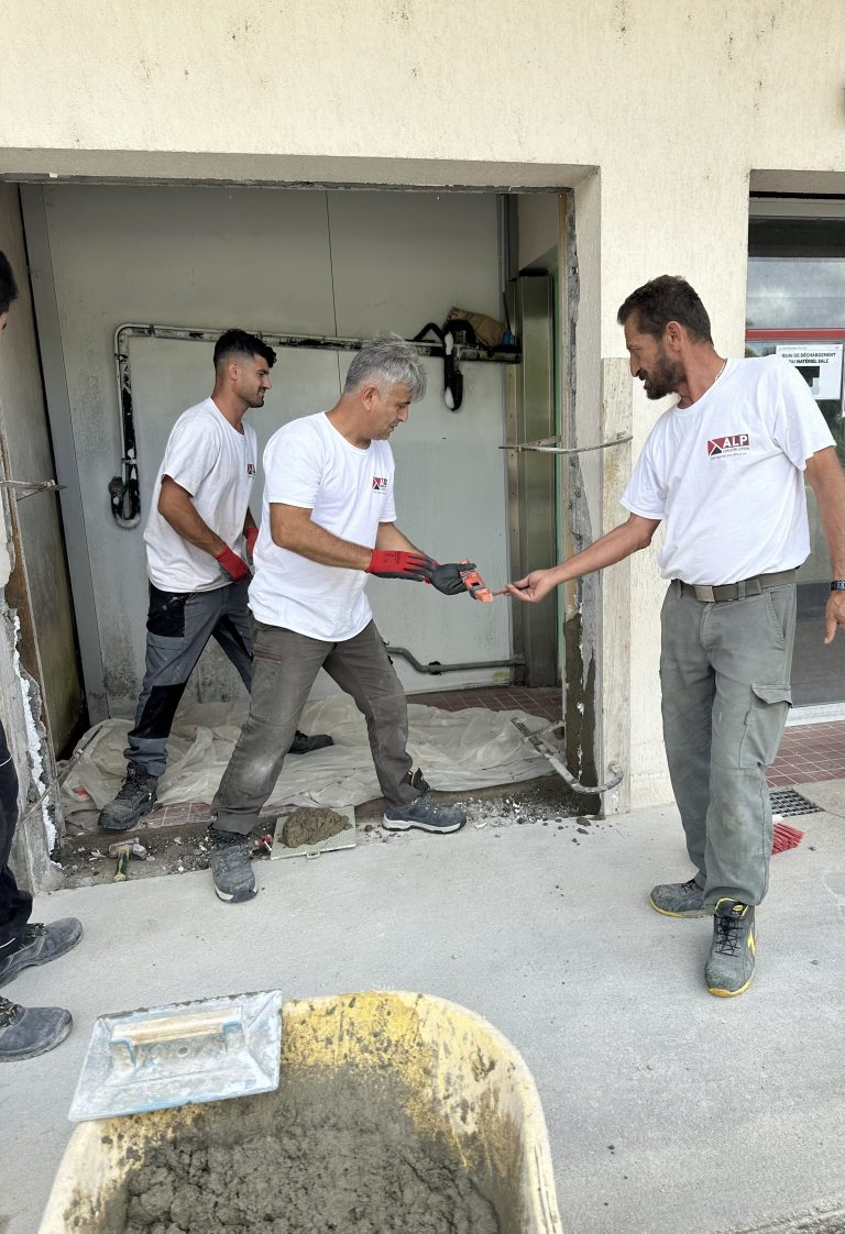 Équipe ALP au travail : béton et maçonnerie, avec le logo ALP visible sur les vêtements.
