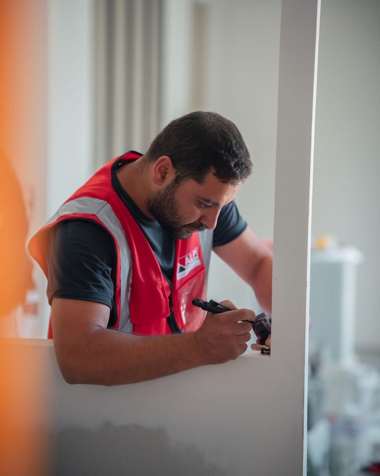 Équipe ALP au travail : menuiserie, avec le logo ALP visible sur les vêtements.