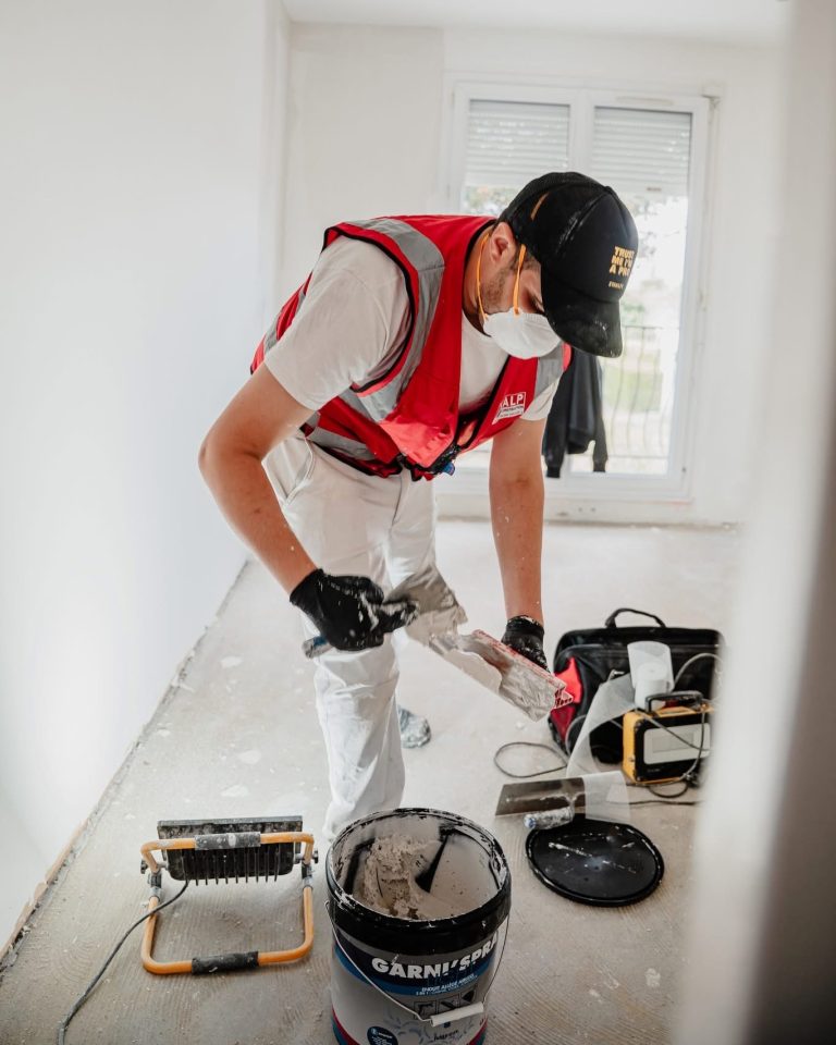 Équipe ALP au travail : peinture, avec le logo ALP visible sur les vêtements.