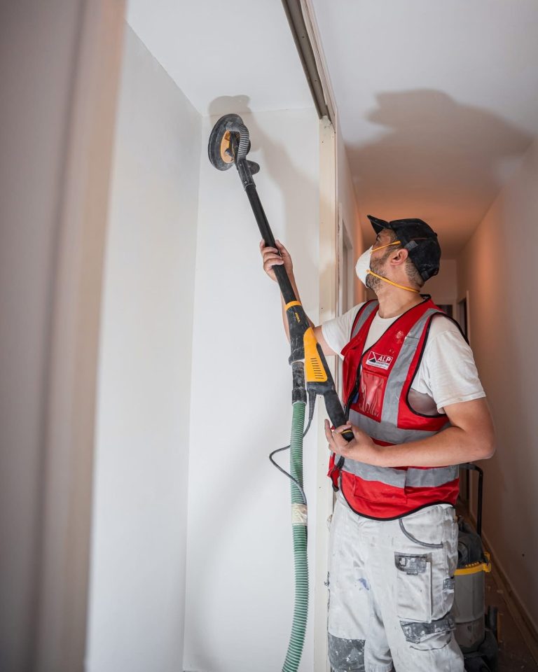 Équipe ALP au travail : plâtrerie et rénovation, avec le logo ALP visible sur les vêtements.