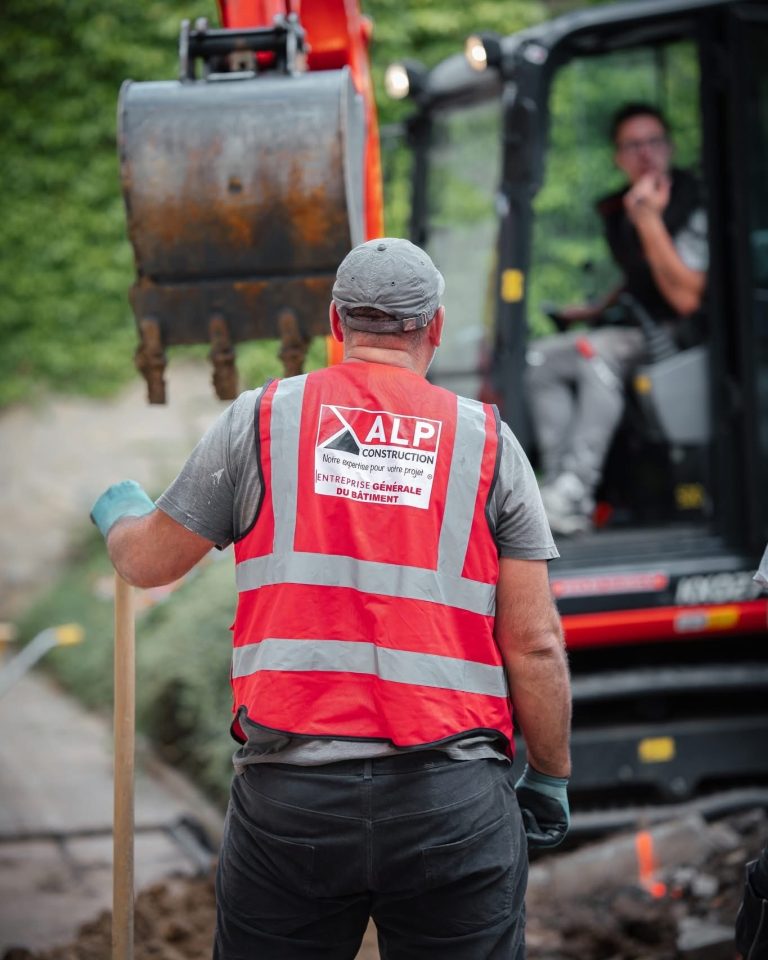 Équipe ALP au travail : terrassement et engins, avec le logo ALP visible sur les vêtements.