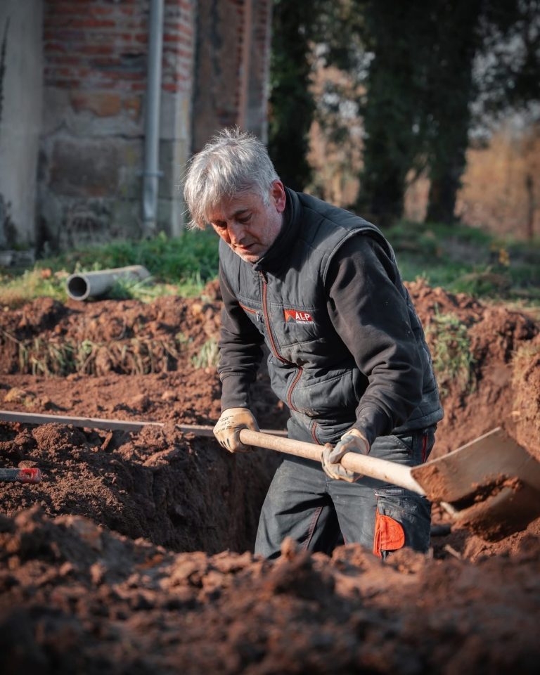 Équipe ALP au travail : terrassement et engins, avec le logo ALP visible sur les vêtements.