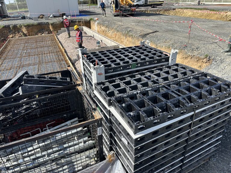 Plusieurs salariés ALP préparent un plancher avec des armatures et des éléments de coffrage.