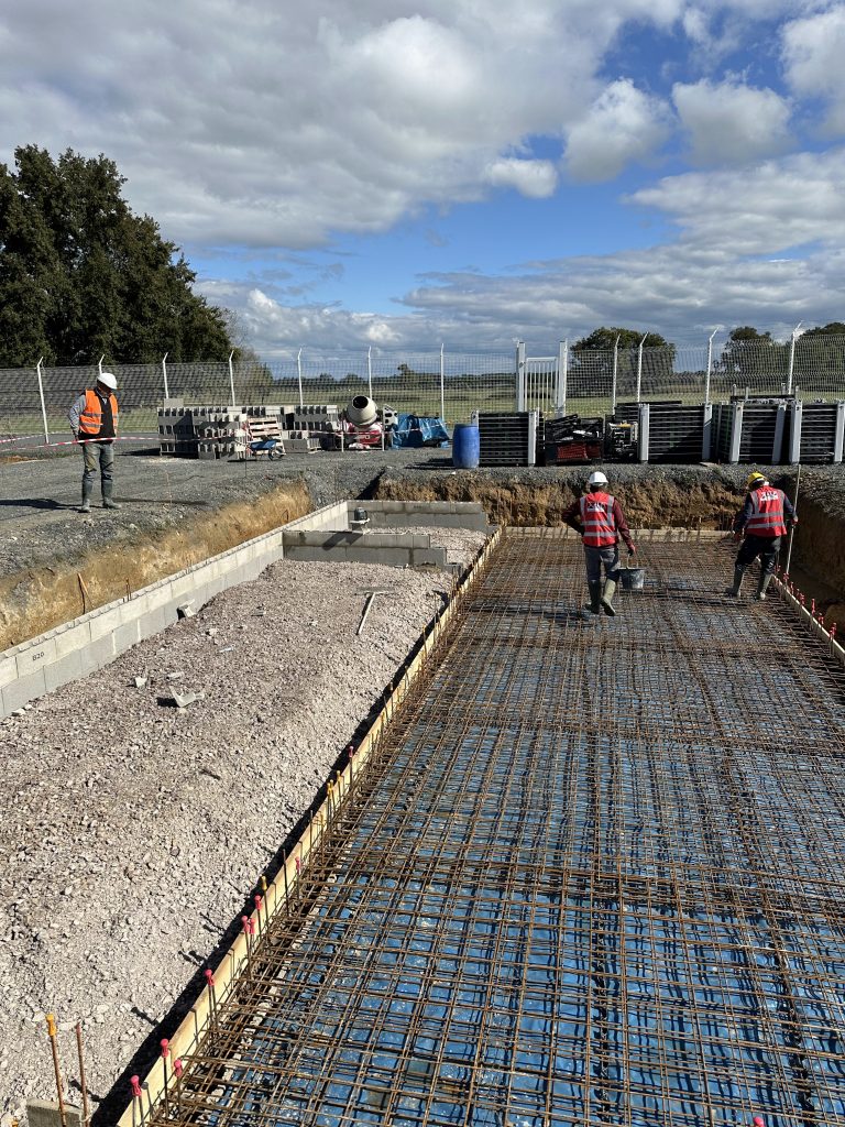 L’équipe ALP prépare le coulage d’un plancher, avec les gilets au logo de l’entreprise visibles.
